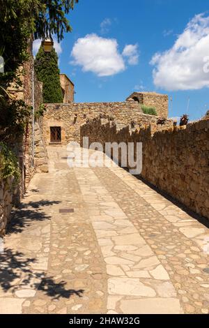 Strada di pietra in una pittoresca cittadina sulla Costa Brava in una giornata estiva soleggiata Foto Stock