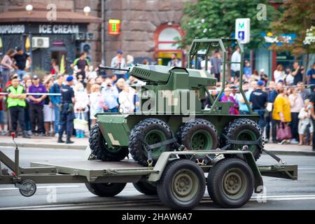 Ucraina, Kiev - 18 agosto 2021: Mini-serbatoio radiocontrollato semovente. Cannone senza equipaggio. Parata militare. Veicolo blindato . Trasporto in colori protettivi. Veicoli militari SUV. Foto Stock