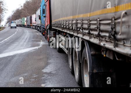 REGIONE DI ZAKARPATTIA, UCRAINA - 15 DICEMBRE 2021 - i camion sono parcheggiati dalla strada della strada che conduce al checkpoint Uzhhorod-Vysne Nemecke su Foto Stock