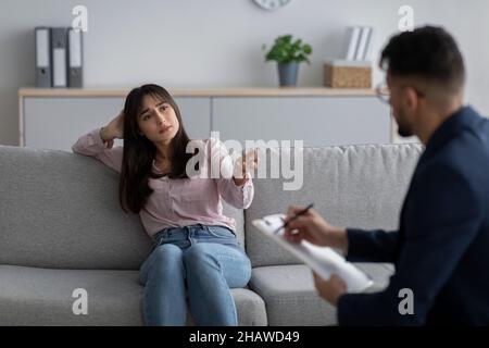 Donna araba stressata e sconvolsa che soffre di depressione, parla con lo psicologo presso l'ufficio medico, lo spazio libero Foto Stock