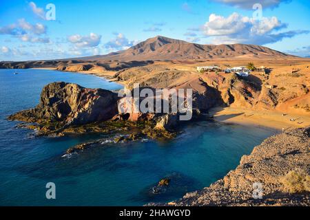 Costa de Papagayo a Lanzarote, Spagna, con i due bar e la catena montuosa Los Ajaches sullo sfondo. Una serata di sole con alcune nuvole in un b Foto Stock