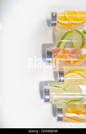 Varietà di bevande fredde in bottiglia, bottiglie d'acqua infuse d'estate, limonata cocktail sani con diversi agrumi - limone, arancia, pompelmo, Foto Stock