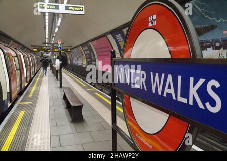 Londra, UK, 15 dicembre 2021: Passeggiate invernali è un'attività suggerita alla stazione della metropolitana Clapham Common come parte della pubblicità per la campagna #LetsDoLondon del Sindaco. Il solito rondel è stato coperto da un cartello temporaneo come parte di una campagna per ricordare alle persone che possono ancora essere fuori e circa a Londra. Le passeggiate invernali sono probabilmente una delle attività più sicure possibile, in quanto le persone sono sempre più incoraggiate a considerare la loro e la sicurezza degli altri a causa della rapida diffusione della variante omicron. Anna Watson/Alamy Live News. Foto Stock