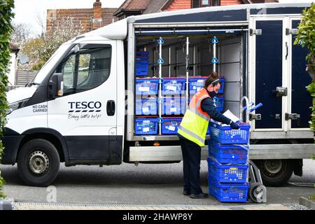 Tesco supermercato online shopping consegna furgone conducente donna indossare alta visibilità staff uniforme scarico cibo cliente fuori casa Inghilterra UK Foto Stock