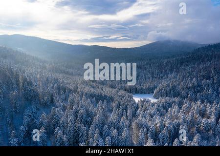 Vista panoramica del bellissimo paesaggio invernale delle meraviglie con tradizionale rifugio in legno, preso dal drone. Concetto di vacanza di Natale Foto Stock