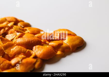 Sfondo di agrumi. Sfocatura sfondo Natale sfocato dalle bucce di arancio e mandarino su sfondo bianco. Molti piccoli pezzi di buccia secca. Foto Stock