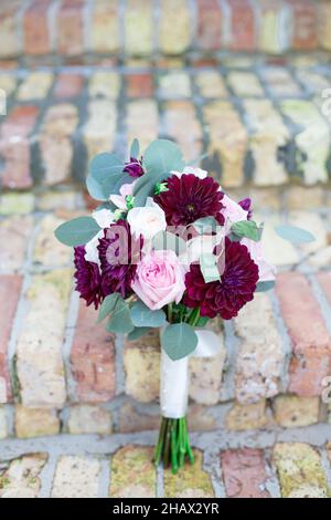 Bouquet rosso rosa e bianco floreale su scale in mattoni Foto Stock