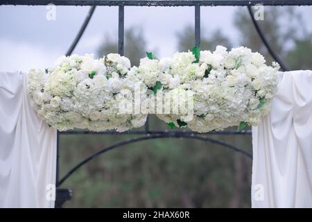 Beutiful arco di nozze in ghisa con decorazioni di fiori di hydreangea fuori Foto Stock
