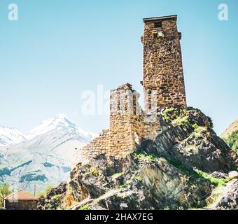 Immagine ravvicinata della torre di guardia nel villaggio di Sno a Kazbegi con la vetta del monte Kazbek. Foto Stock