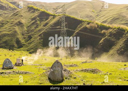 Rock heads in mostra nel parco nazionale di Kazbegi con artista al lavoro i sfondo. Arte e attrazioni turistiche in montagna. Foto Stock