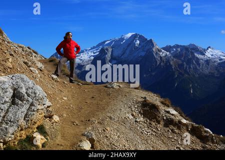 Dolomiten, schöne Frau wandert auf Berge und Felsen am Langkofel, Sasso lungo mit Blick und Aussicht auf die Marmolada, Marmolata in Südtirol Foto Stock