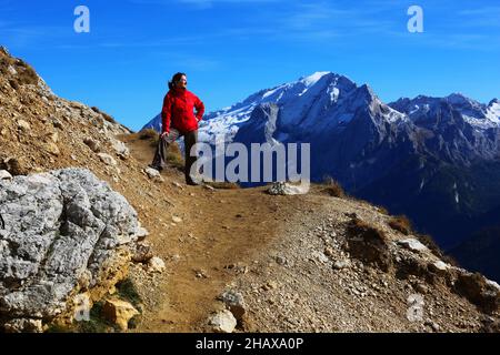 Dolomiten, schöne Frau wandert auf Berge und Felsen am Langkofel, Sasso lungo mit Blick und Aussicht auf die Marmolada, Marmolata in Südtirol Foto Stock