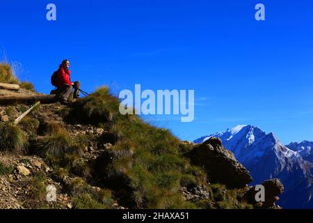 Dolomiten, schöne Frau wandert auf Berge und Felsen am Langkofel, Sasso lungo mit Blick und Aussicht auf die Marmolada, Marmolata in Südtirol Foto Stock