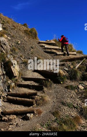 Dolomiten, schöne Frau wandert auf Berge und Felsen am Langkofel, Sasso lungo mit Blick und Aussicht auf die Marmolada, Marmolata in Südtirol Foto Stock