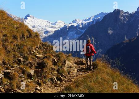 Dolomiten, schöne Frau wandert auf Berge und Felsen am Langkofel, Sasso lungo mit Blick und Aussicht auf die Marmolada, Marmolata in Südtirol Foto Stock