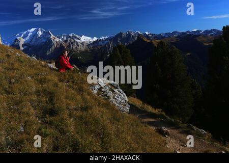 Dolomiten, schöne Frau wandert auf Berge und Felsen am Langkofel, Sasso lungo mit Blick und Aussicht auf die Marmolada, Marmolata in Südtirol Foto Stock