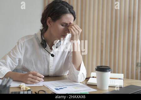 Stanco lavoratrice domestica spagnola che massaggiava il naso o gli angoli interni degli occhi Foto Stock