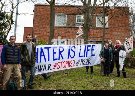 Londra, Regno Unito. 15th dicembre 2021. Stop HS2 gli attivisti posano con un banner fuori dalla Corte dei Magistrati di Uxbridge. Gli attivisti includono l'ex paralimpiano miope James Brown e il compagno di attivista 'Jimmy' (entrambi a sinistra) Che apparivano in tribunale accusati di danni criminali dopo aver presumibilmente arrampicato un carro di perforazione da utilizzare per il progetto ferroviario ad alta velocità del HS2 nel febbraio 2020 al fine di sensibilizzare i rischi derivanti dal lavoro infrastrutturale all'approvvigionamento idrico di Londra dalla falda acquifera di gesso al di sotto della valle di Colne. Il caso è stato rinnegato fino al febbraio 2022. Credit: Mark Kerrison/Alamy Live NE Foto Stock