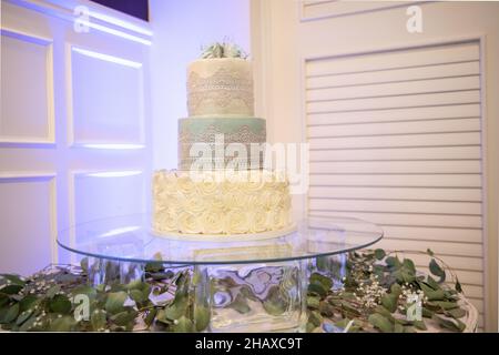 Torta nuziale a tre livelli bianca Beaautiful con coprimaterasso di fiori blu Foto Stock