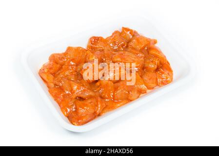 Vassoio di pezzetti di pollo piccante su sfondo bianco Foto Stock