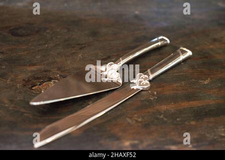 Utensili per servire la torta d'argento con disegni a cuore su tavola di legno Foto Stock