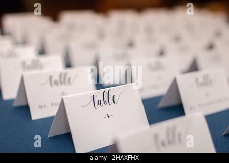 File di bianco ripiegato tavolo posizionare carte su blu matrimonio receptin tavolo Foto Stock