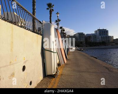 Barche appoggiate contro un muro nel porto, Bugibba, Malta Foto Stock