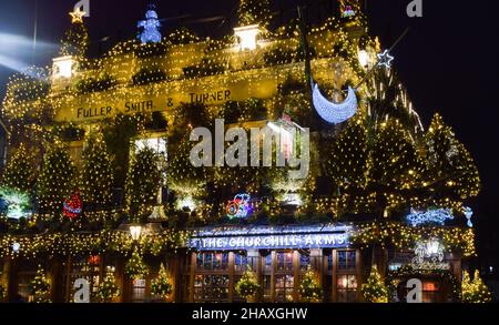 Londra, Regno Unito 15th dicembre 2021. Decorazioni natalizie al Churchill Arms di Kensington. 80 alberi e migliaia di luci adornano l'esterno del famoso pub. Credit: Vuk Valcic / Alamy Live News Foto Stock