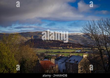 Una vista dal Castello di Stirling guardando verso il monumento Wallace in Scozia con una leggera spolverata di neve sulle colline Foto Stock