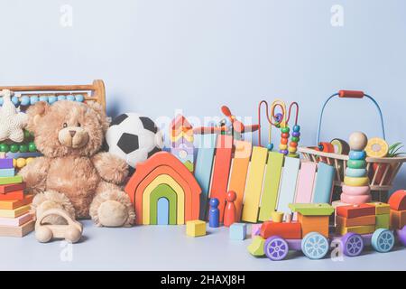Collezione di giocattoli per bambini isolata su sfondo blu. Orsacchiotto, in legno, plastica e morbido set di giocattoli per bambini. Vista frontale Foto Stock