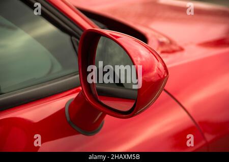 Specchietto retrovisore. Parte di un'auto rossa da vicino Foto Stock