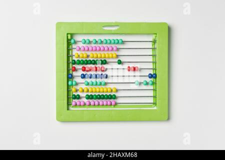 Calcolatrice a perle colorate su bianco. Contatore manuale di sfere in plastica verde per matematica. Abaco colorato con perline. Istruzione scolastica, calcolatrice per prescolare Foto Stock