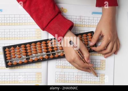 Fare matematica mentale o aritmetica mentale. Mano di ragazzino che usa abaco per calcolare. Imparare ad usare abacus nei corsi di matematica mentale. Un bambino che fa Foto Stock