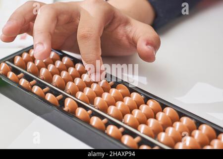 Fare matematica mentale o aritmetica mentale. Mano di ragazzino che usa abaco per calcolare. Imparare ad usare abacus nei corsi di matematica mentale. Un bambino che fa Foto Stock