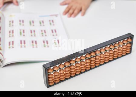 Fare matematica mentale o aritmetica mentale. Mano di ragazzino che usa abaco per calcolare. Imparare ad usare abacus nei corsi di matematica mentale. Un bambino che fa Foto Stock