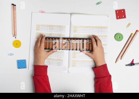 Fare matematica mentale o aritmetica mentale. Mano di ragazzino che usa abaco per calcolare. Imparare ad usare abacus nei corsi di matematica mentale. Un bambino che fa Foto Stock