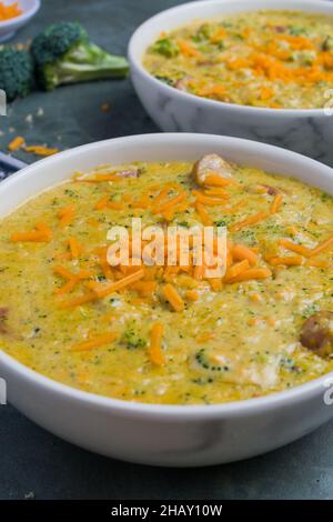 Ciotole con deliziosa zuppa di broccoli e formaggio poste sul tavolo grigio del ristorante Foto Stock