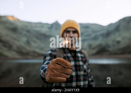 Vista posteriore di un surfista maschile irriconoscibile in muta preparazione tavola da surf sulla costa sabbiosa vuota dell'isola di Lanzarote in Spagna Foto Stock