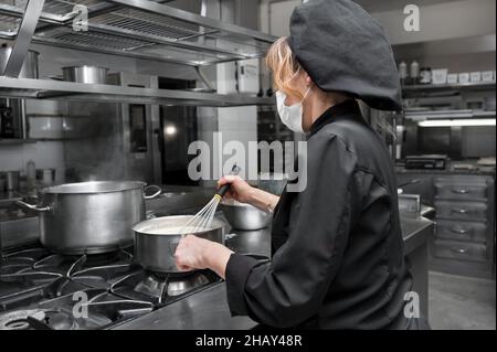 Ritratto di fiducioso chef femminile che lavora in cucina commerciale. Foto di alta qualità Foto Stock