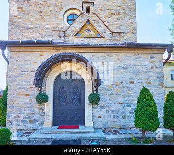 La bella porta principale ad arco della Chiesa della Santissima Trinità, decorata con rilievi di Dio Padre, il Figlio e lo Spirito Santo, Kamianets-Podilskyi, Ucraina Foto Stock