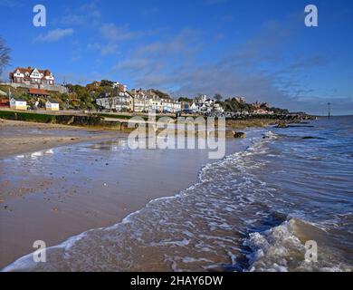 Felixstowe, Suffolk, Regno Unito: Le onde si infrangono contro la spiaggia sabbiosa nella località turistica inglese di Felixstowe. La gente cammina lungo il lungomare e la spiaggia. Foto Stock