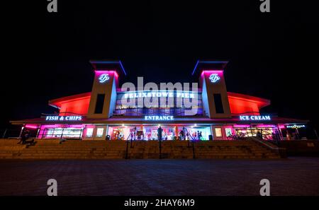 Felixstowe, Suffolk, Regno Unito: L'ingresso al molo di Felixstowe di notte illuminato da luci rosse. Foto Stock