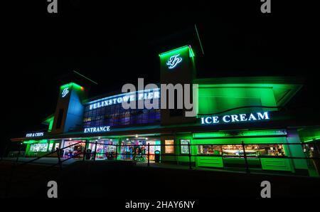 Felixstowe, Suffolk, Regno Unito: L'ingresso al molo di Felixstowe di notte illuminato da luci verdi. Foto Stock