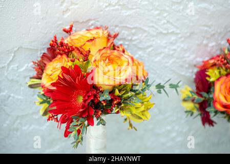 Gerber Daisies e rose gialle sposano contro il muro di cemento Foto Stock