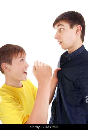 Kid minaccia di Teenager con un pugno isolato sullo sfondo bianco Foto Stock