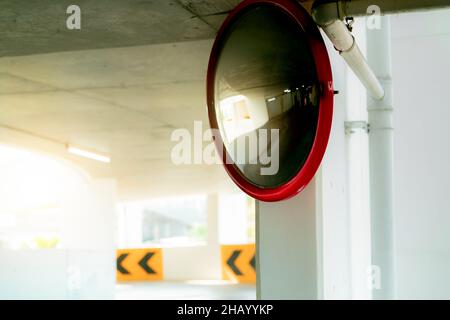 Specchio di sicurezza convesso in corrispondenza della curva del parcheggio interno per ridurre il rischio di incidenti in corrispondenza di angoli o punti ciechi. Specchio di sicurezza circolare convesso Foto Stock