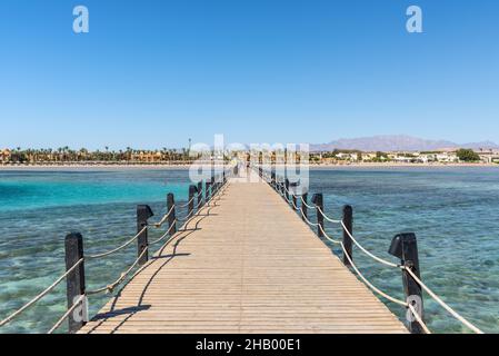 Hurghada, Egitto - 25 maggio 2021: Lungo molo di legno che conduce sul mare allo Stella di Mare Beach Resort situato nella Baia di Makadi, che uno di Egitto Foto Stock