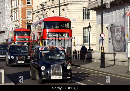 Londra, Inghilterra, Regno Unito. Autobus a due piani rossi e taxi neri a Whitehall Foto Stock