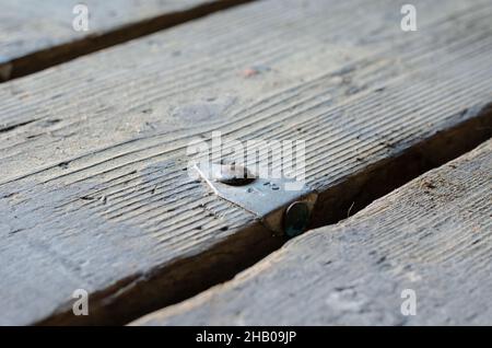 Numero 13. Una vecchia tavola con un'etichetta in alluminio. Barra di metallo inchiodata al pavimento. Primo piano. Messa a fuoco selettiva. Foto Stock