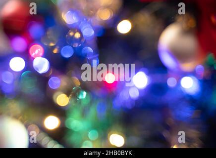 Un'immagine sfocata di un albero di Natale decorato con ghirlande di notte. Sfondo di Natale. Foto Stock